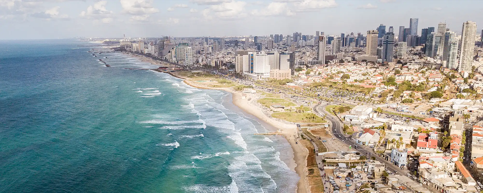 Vue de la côte de Tel-Aviv avec la ligne d’horizon urbaine, illustrant la reprise des vols de Swiss vers cette destination.