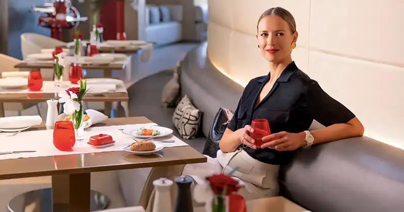 Cliente installée dans l’espace restaurant du salon La Première d’Air France avec table dressée