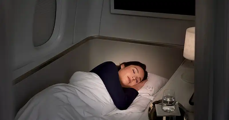 Passagère reposant dans le lit de la suite La Première d’Air France avec éclairage doux
